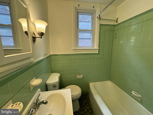 bathroom featuring toilet, sink, and tile walls