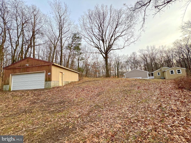 view of yard featuring a garage and an outdoor structure