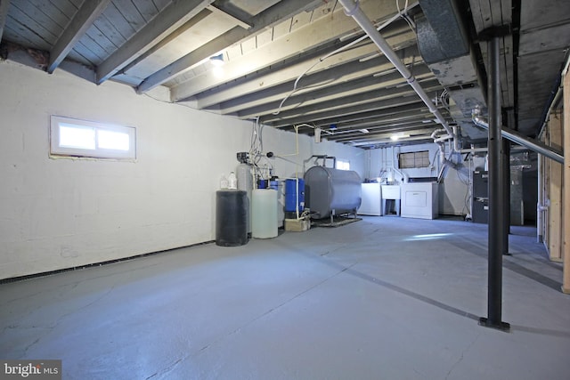 basement featuring heating unit and washing machine and clothes dryer