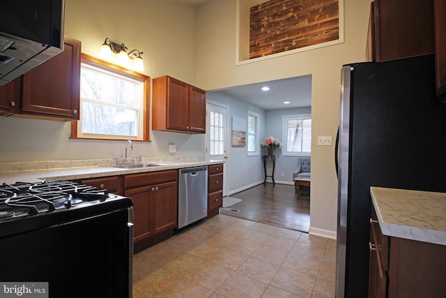 kitchen with stainless steel appliances, light tile patterned flooring, and sink