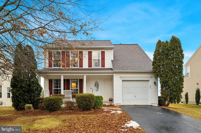 view of property featuring a porch and a garage