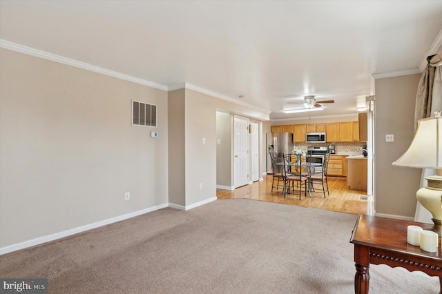 living room with light carpet, crown molding, and ceiling fan