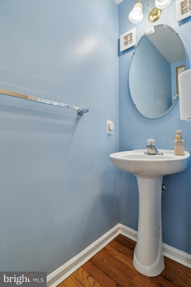 bathroom with hardwood / wood-style flooring, sink, and a chandelier