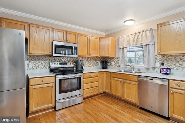 kitchen featuring sink, light hardwood / wood-style flooring, appliances with stainless steel finishes, backsplash, and ornamental molding