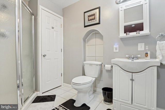 bathroom with vanity, a shower with shower door, tile patterned floors, and toilet