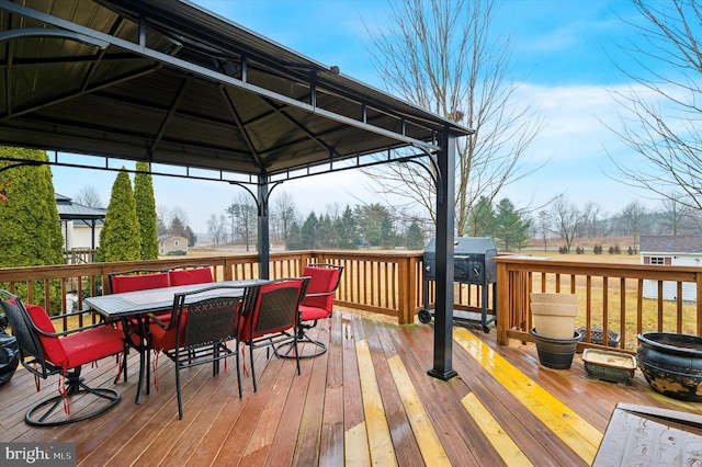 wooden terrace featuring a gazebo and a grill