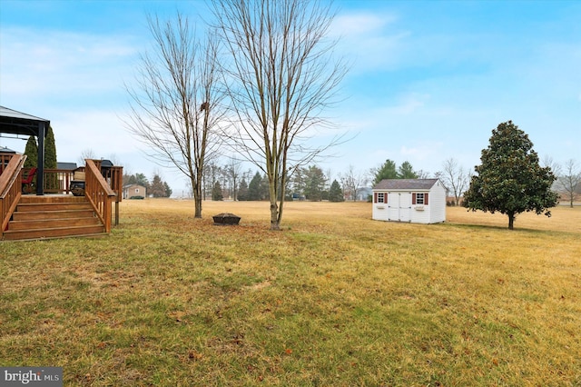 view of yard with a deck and a storage shed