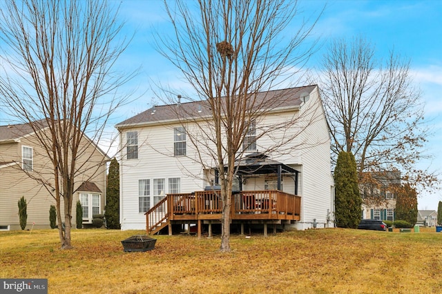 rear view of house featuring an outdoor fire pit, a yard, and a deck