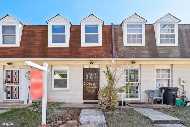 multi unit property with roof with shingles and brick siding