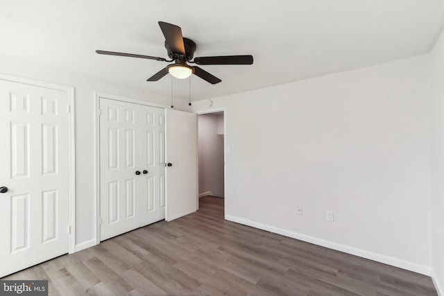 unfurnished bedroom with ceiling fan, baseboards, and wood finished floors