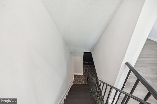 stairway featuring wood finished floors and baseboards