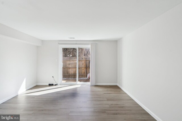 unfurnished room featuring baseboards and wood finished floors