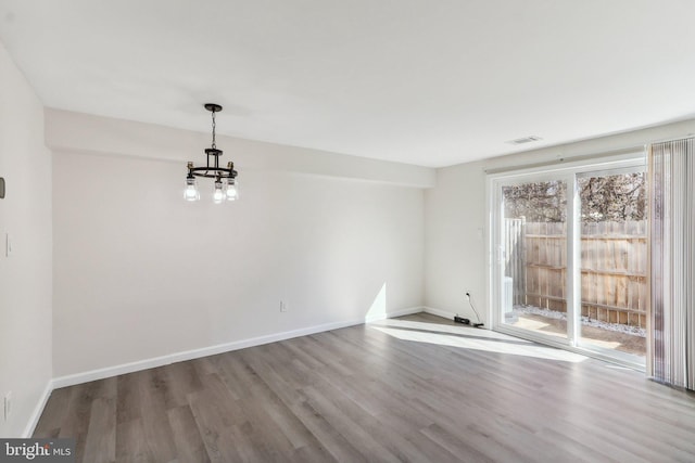 unfurnished dining area featuring wood finished floors, visible vents, and baseboards
