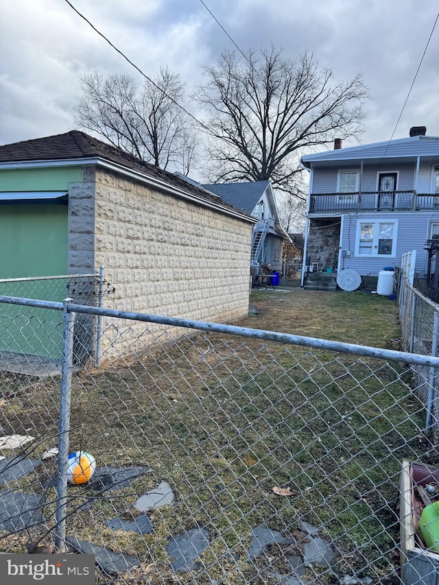 view of side of property featuring fence and a balcony