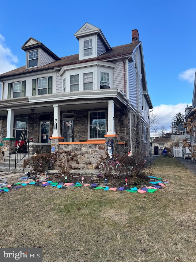 view of front of property featuring covered porch and a front lawn