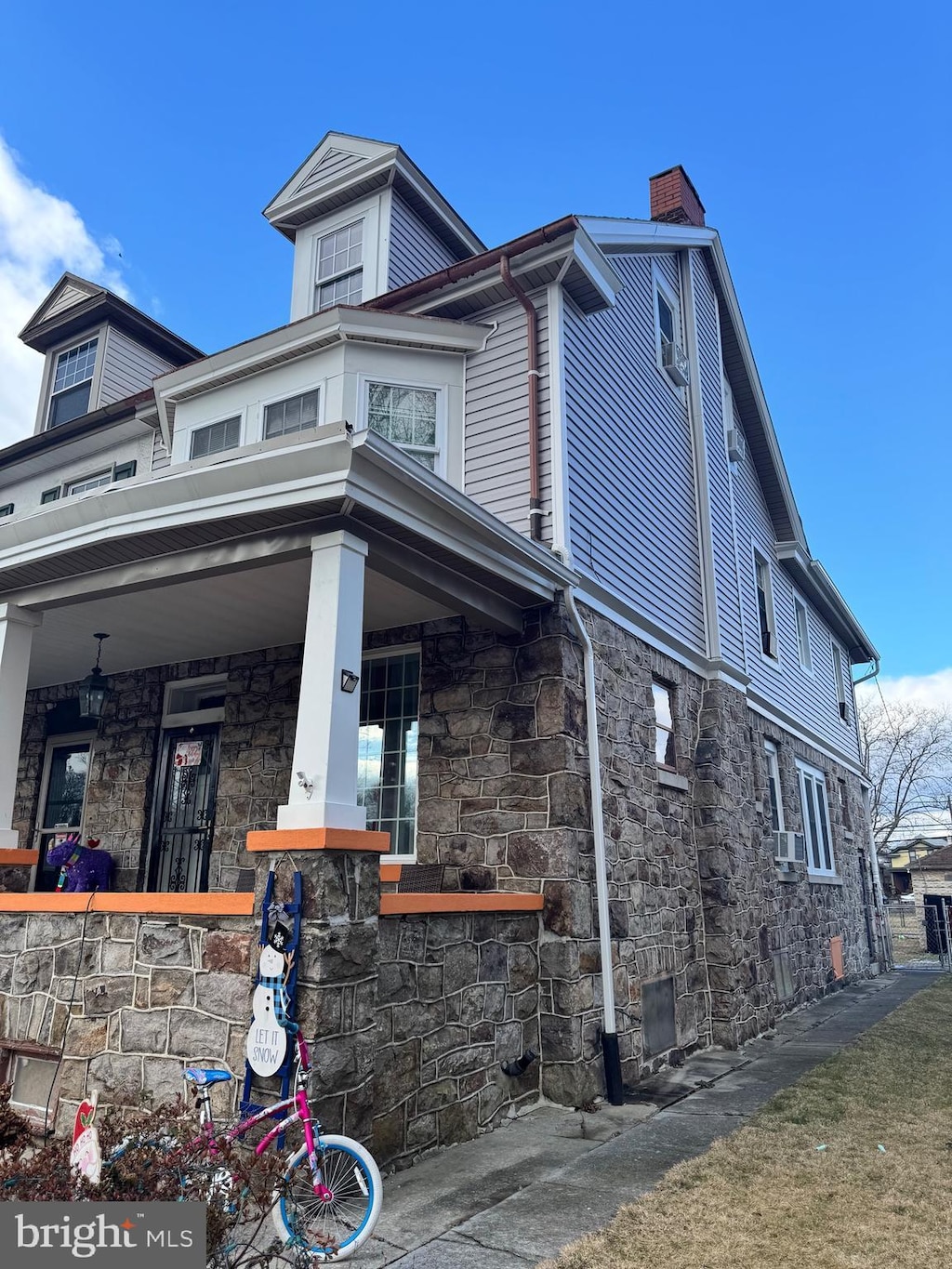 view of side of property featuring cooling unit and covered porch