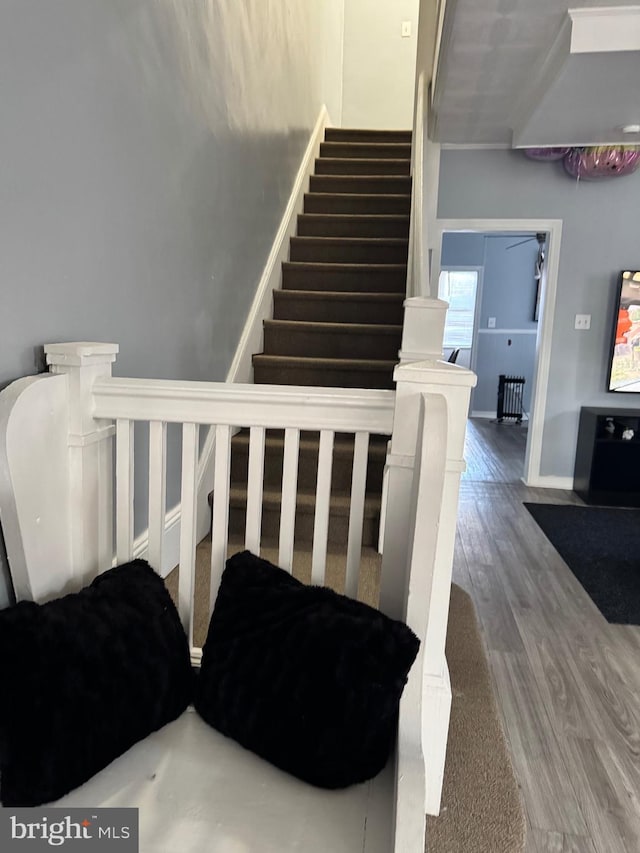 stairway featuring wood finished floors and baseboards