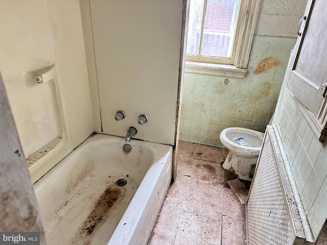 bathroom featuring a washtub and toilet