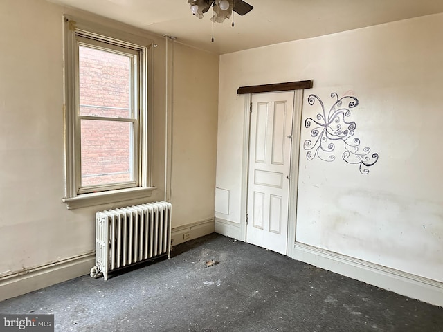 unfurnished room featuring a healthy amount of sunlight, radiator heating unit, and ceiling fan