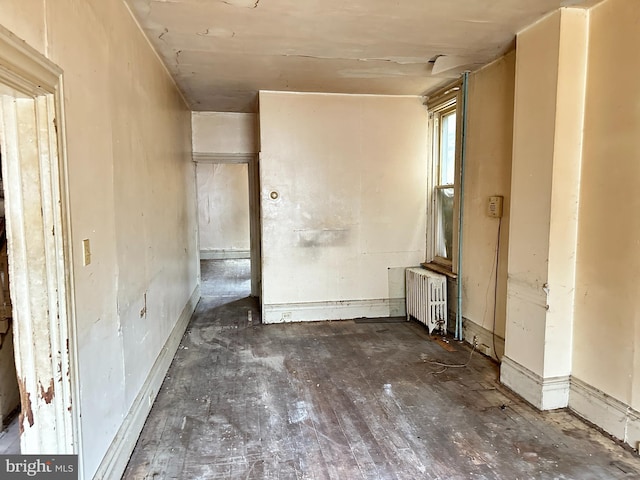 misc room featuring dark wood-type flooring and radiator heating unit