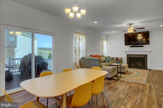 dining room with hardwood / wood-style flooring and ceiling fan with notable chandelier