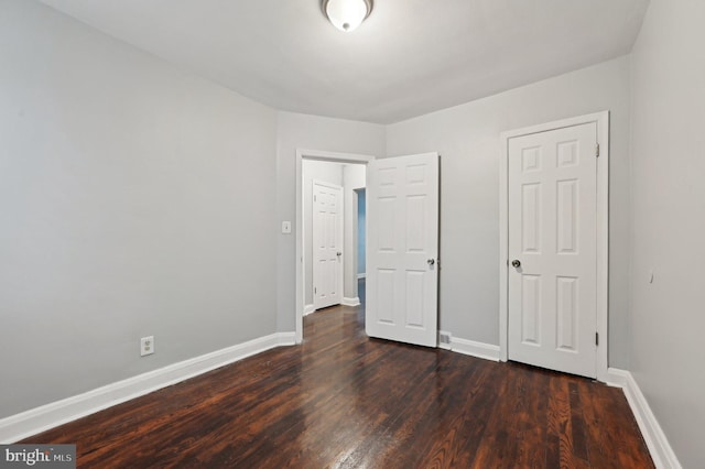 unfurnished bedroom with dark hardwood / wood-style floors