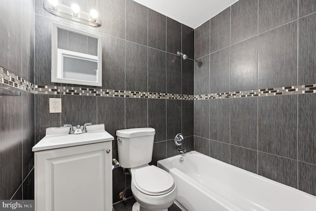 full bathroom with vanity, bathtub / shower combination, tile walls, and toilet