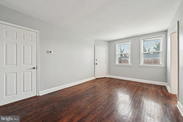 empty room with dark hardwood / wood-style flooring