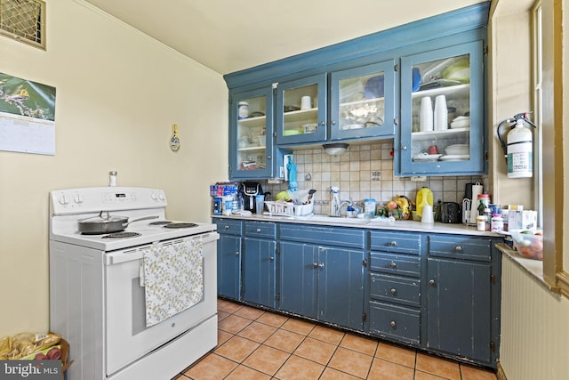 kitchen featuring electric stove, blue cabinetry, decorative backsplash, and light tile patterned floors