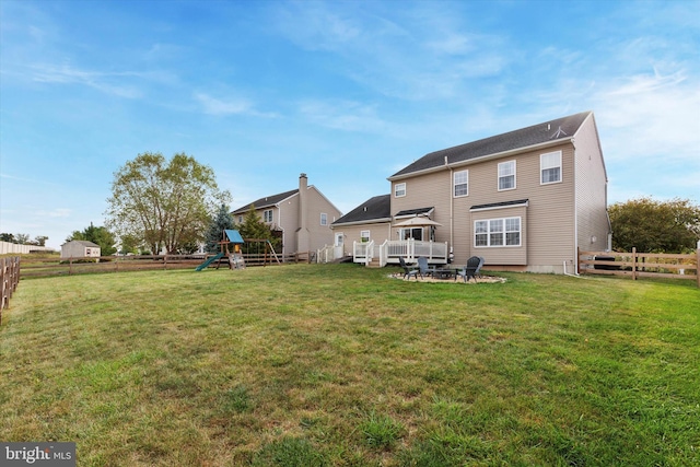 back of property featuring a yard and a playground