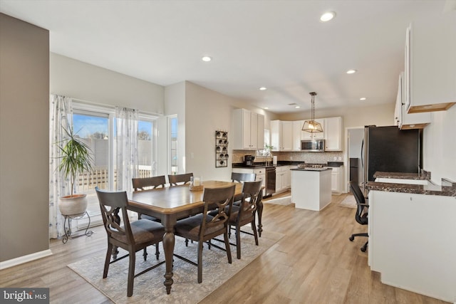 dining area featuring sink and light hardwood / wood-style flooring