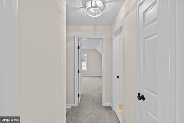 hall with vaulted ceiling and light carpet