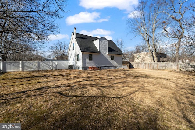 rear view of property featuring a lawn