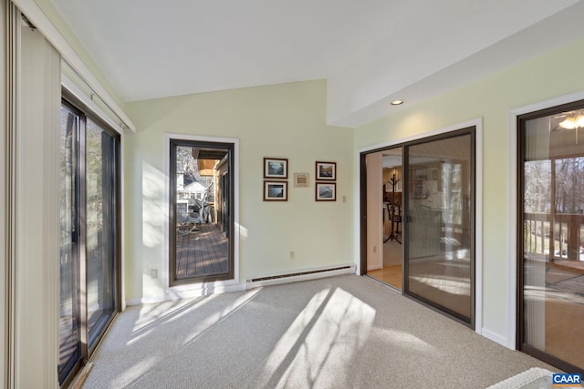 interior space featuring a baseboard radiator, a healthy amount of sunlight, and vaulted ceiling