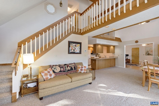 living room featuring carpet floors and high vaulted ceiling