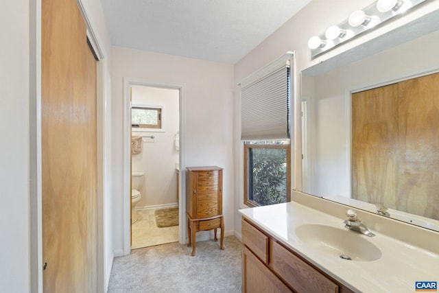 bathroom featuring vanity, a wealth of natural light, and toilet