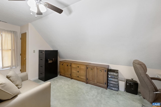 home office with ceiling fan, vaulted ceiling, and light carpet