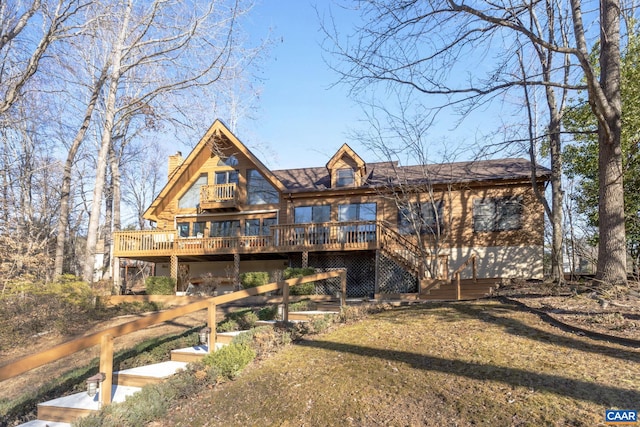 rear view of property featuring a deck and a lawn