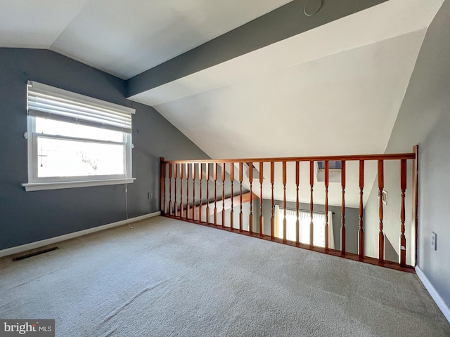 additional living space featuring vaulted ceiling and carpet