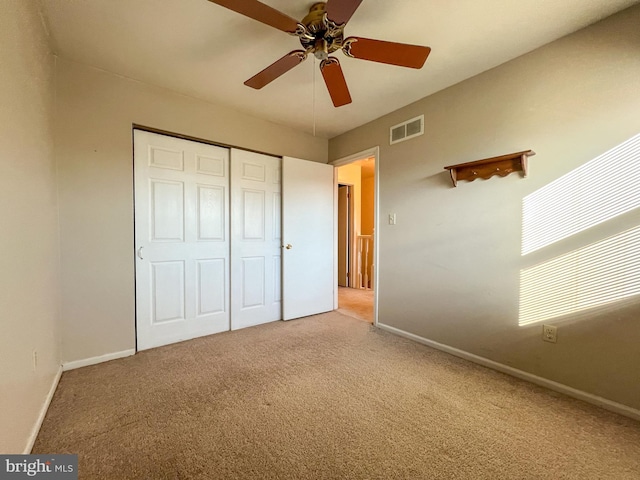 unfurnished bedroom featuring carpet, ceiling fan, and a closet