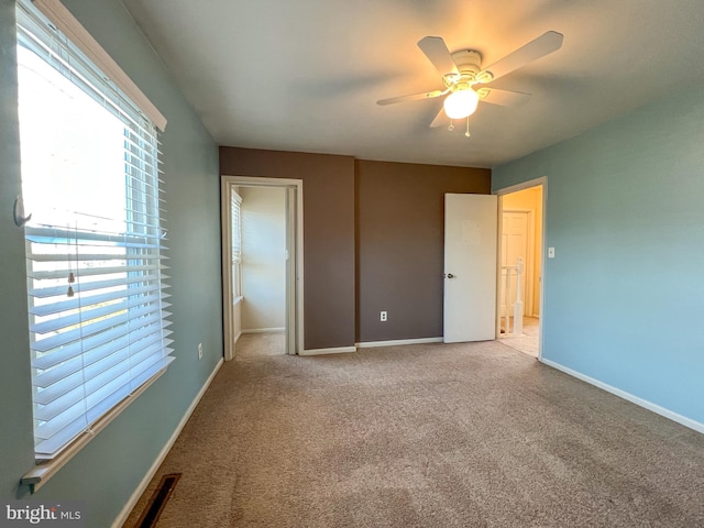 unfurnished bedroom featuring light colored carpet and ceiling fan