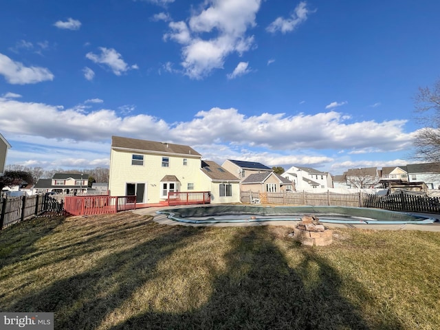 back of property featuring a pool side deck and a yard