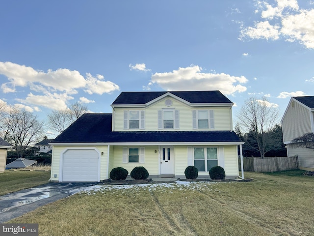 view of property with a garage and a front lawn