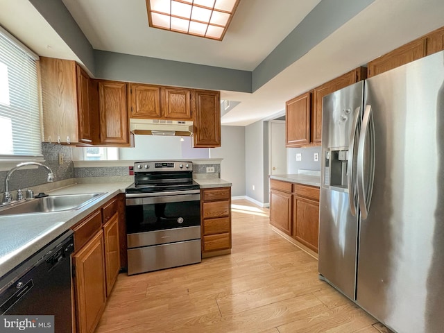 kitchen with sink, backsplash, stainless steel appliances, and light wood-type flooring