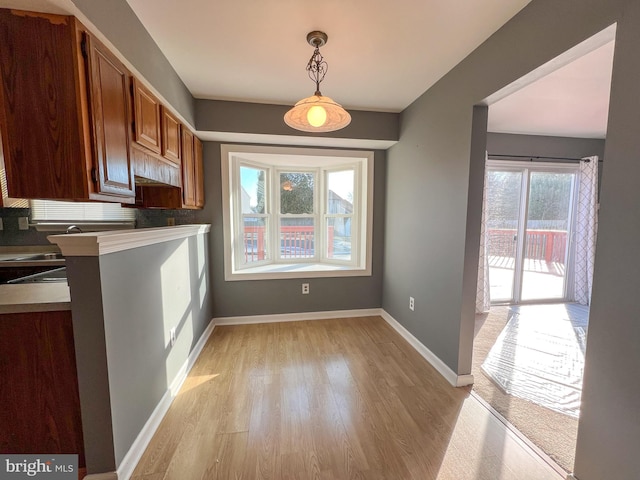 unfurnished dining area with sink and light wood-type flooring