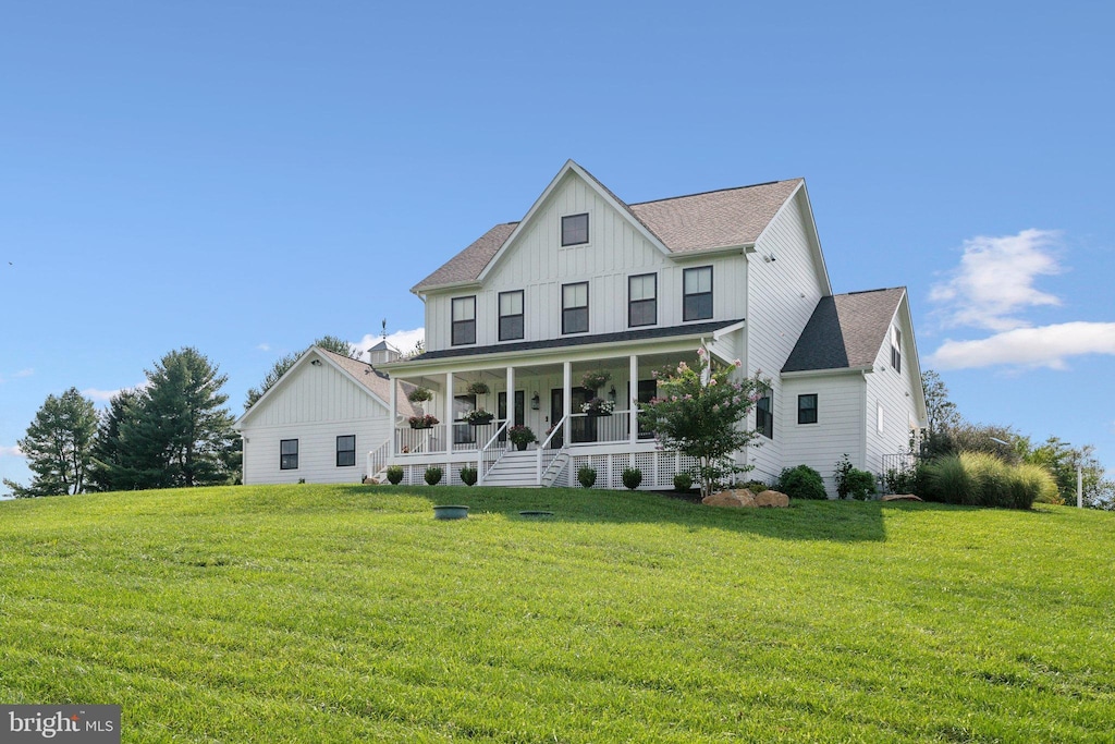 back of property featuring a yard and covered porch