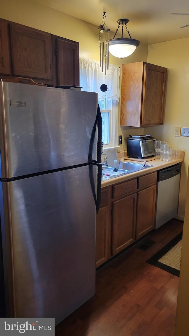 kitchen with dark wood-type flooring, appliances with stainless steel finishes, and sink