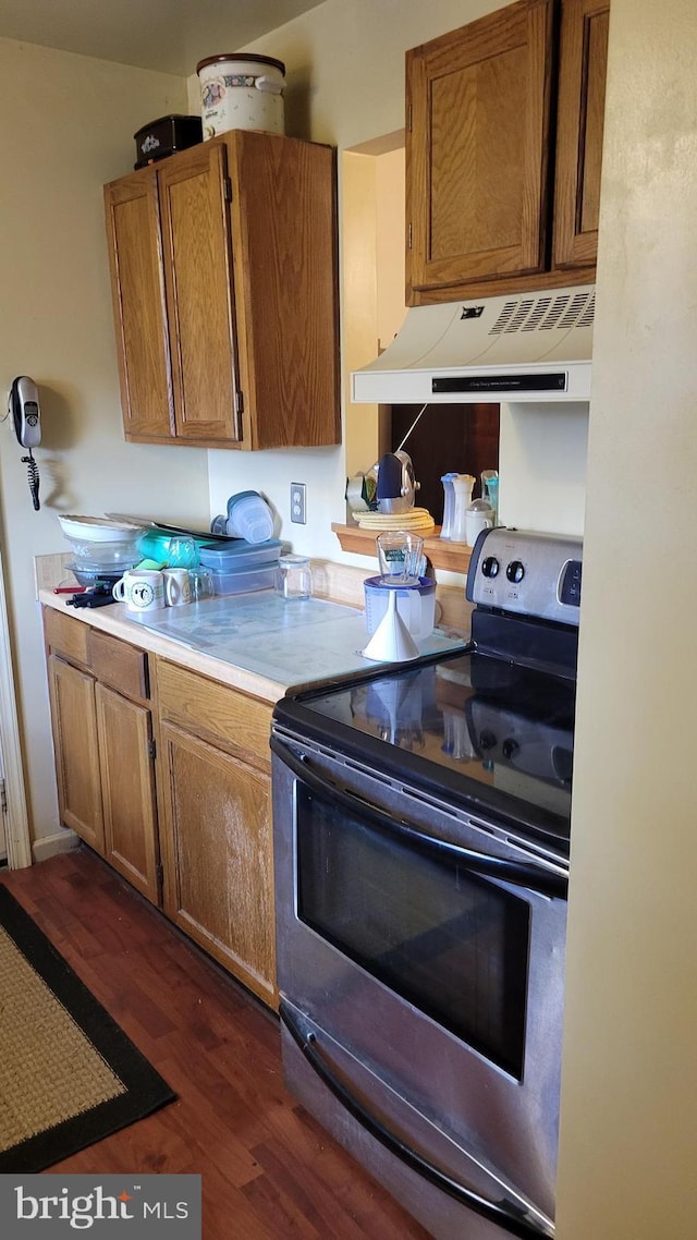 kitchen with range hood, dark hardwood / wood-style flooring, and stainless steel electric range