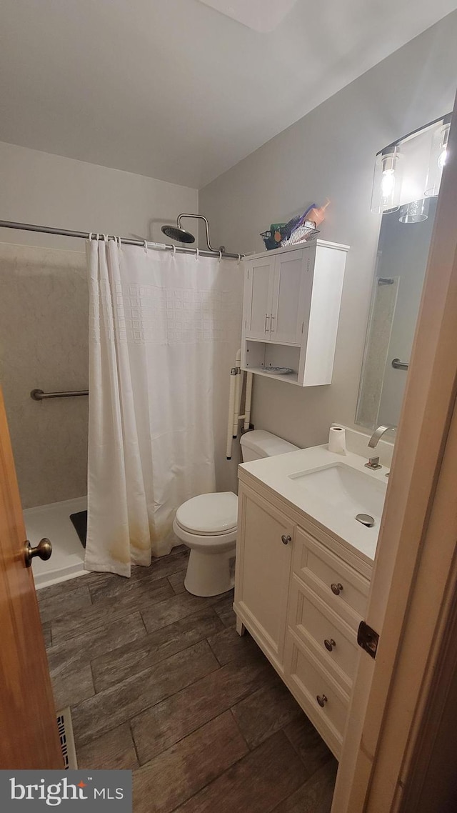 bathroom featuring hardwood / wood-style flooring, vanity, toilet, and a shower with shower curtain