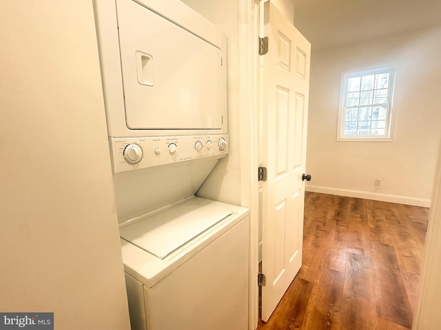 washroom featuring dark hardwood / wood-style floors and stacked washer and clothes dryer